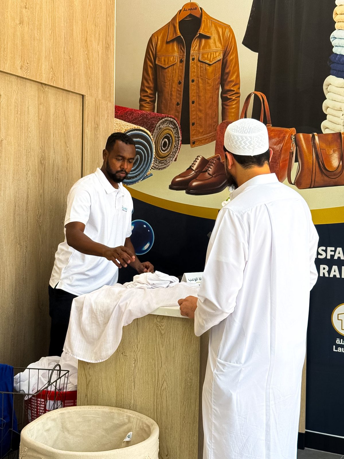 Serving a customer at the Alwaab Laundry Express counter
